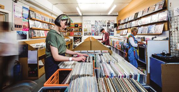 Clients parcourant des bacs de vinyles dans une boutique de disques